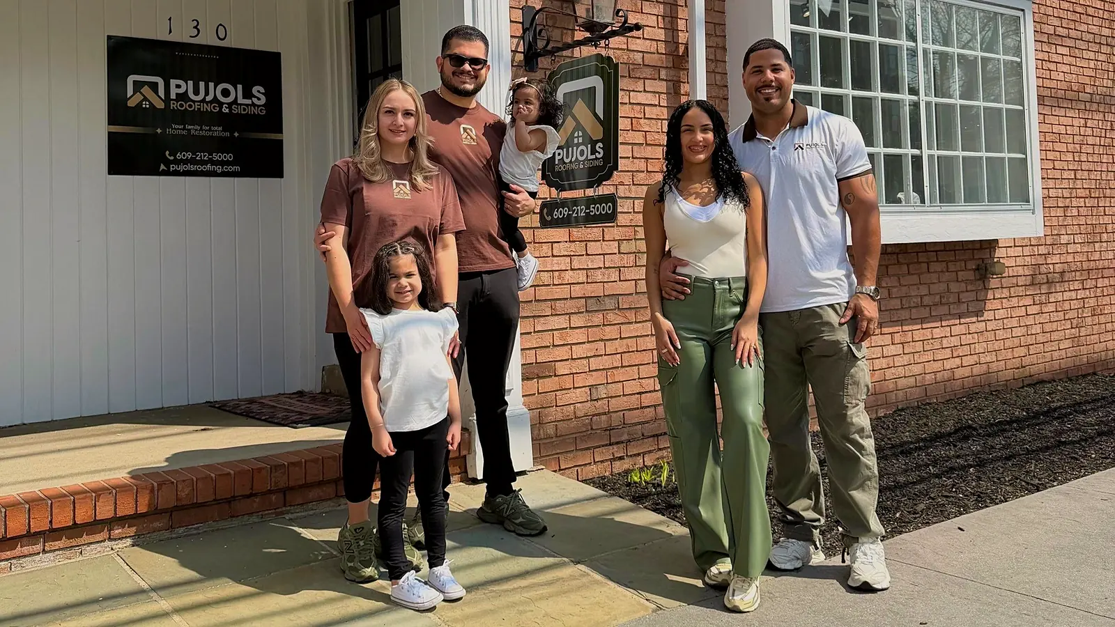The Pujols family, founders of Pujols Roofing & Siding LLC, Enmanuel Marte Pujols (left) with spouse, Meylin Marte, and Gisendry Armstrong Pujols (right), with husband Franklin Armstrong outside their office at 130 Washington St in Rocky Hill, NJ.