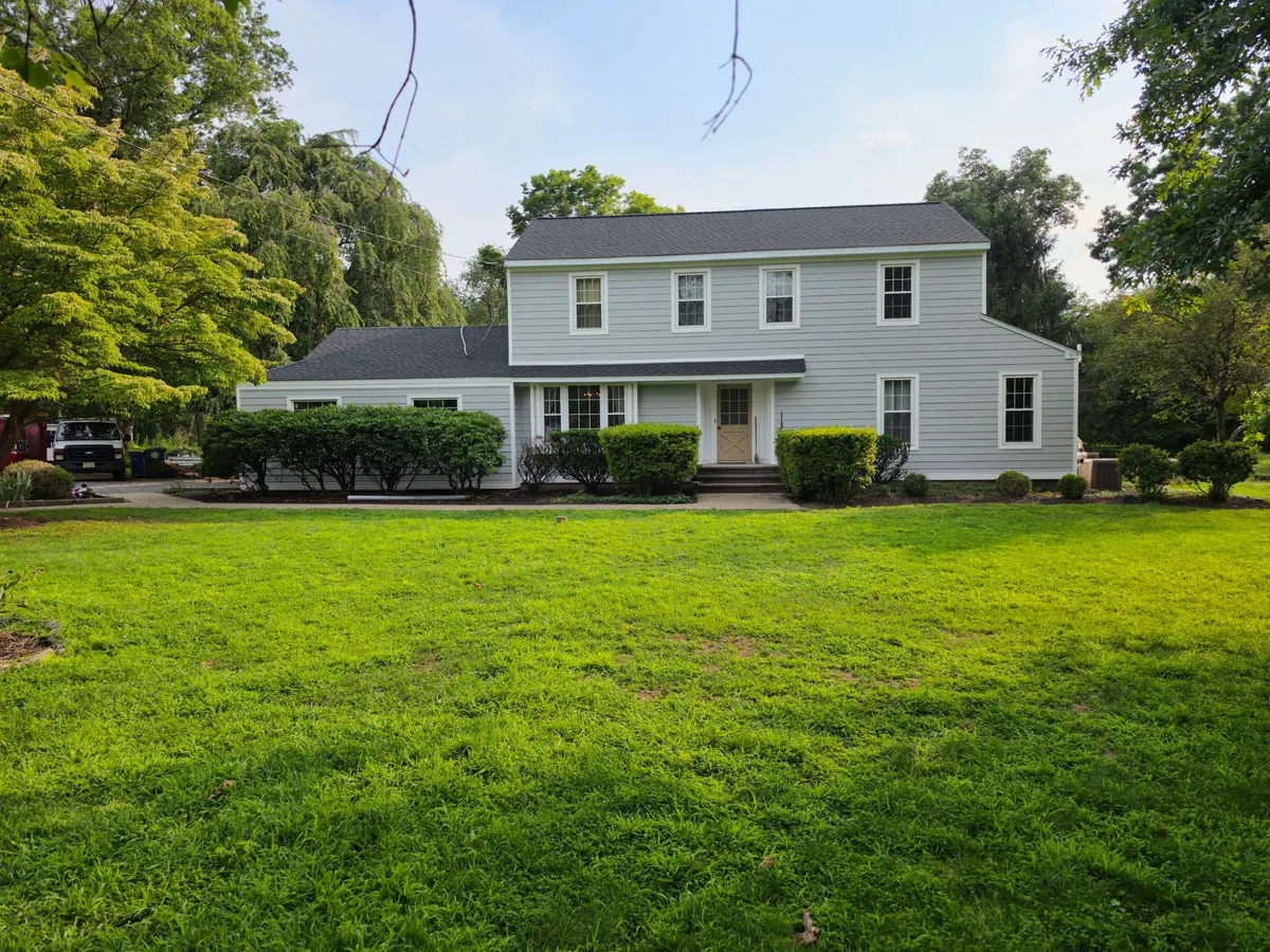 A colonial on Cherry Brook Drive in Princeton, NJ with a new roof, seen from the street, by Pujols Roofing.