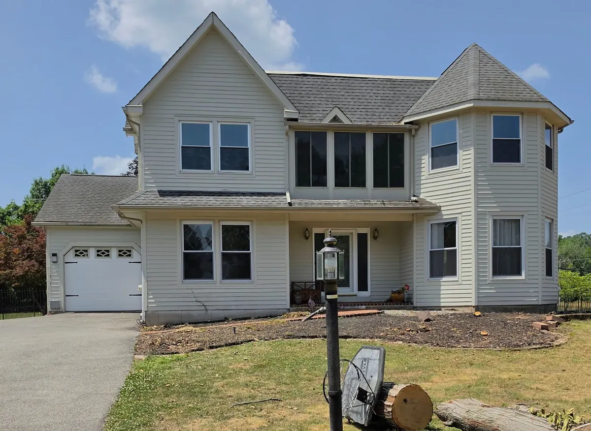 The Jamison, PA house before its makeover, with tan vinyl siding and the old gray roof.