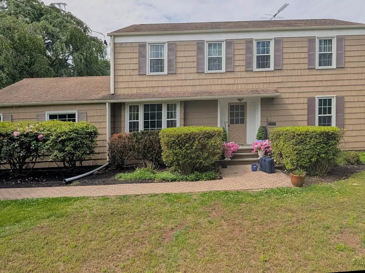 A Princeton colonial before new siding, with worn tan cedar shakes.