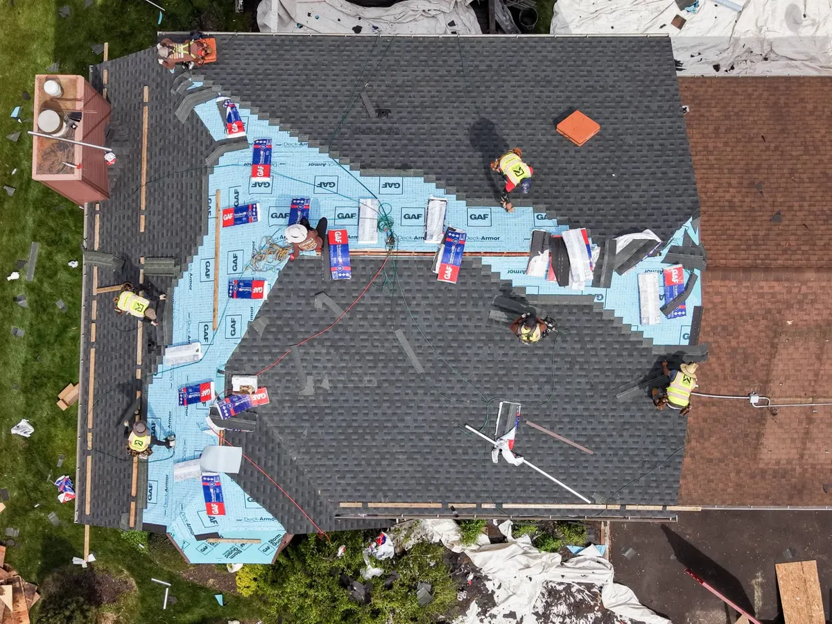 Pujols crew installing GAF Timberline HDZ shingles over blue GAF Deck-Armor underlayment during a roof replacement in Hillsborough, NJ.