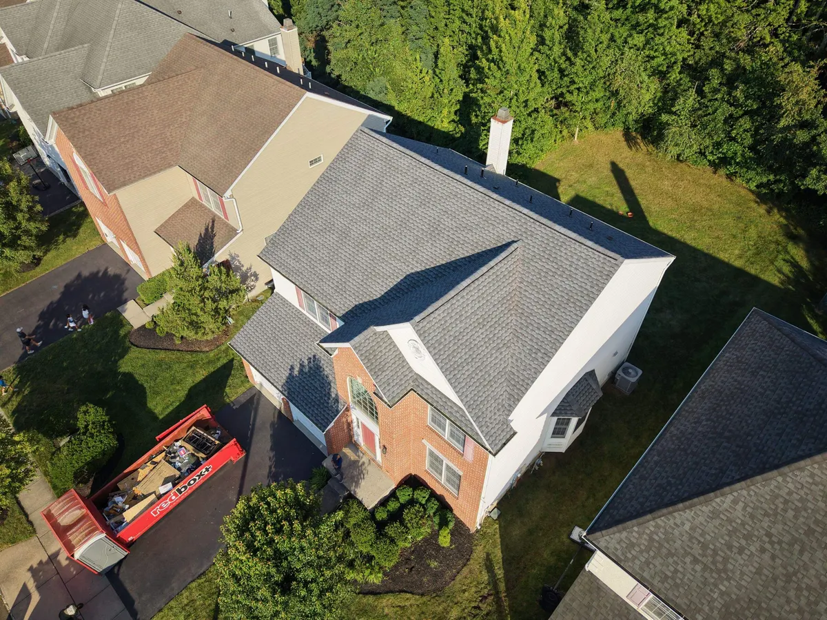 The ridge and chimney of a new shingle roof on Lockwood Drive in Princeton, NJ, by Pujols Roofing.