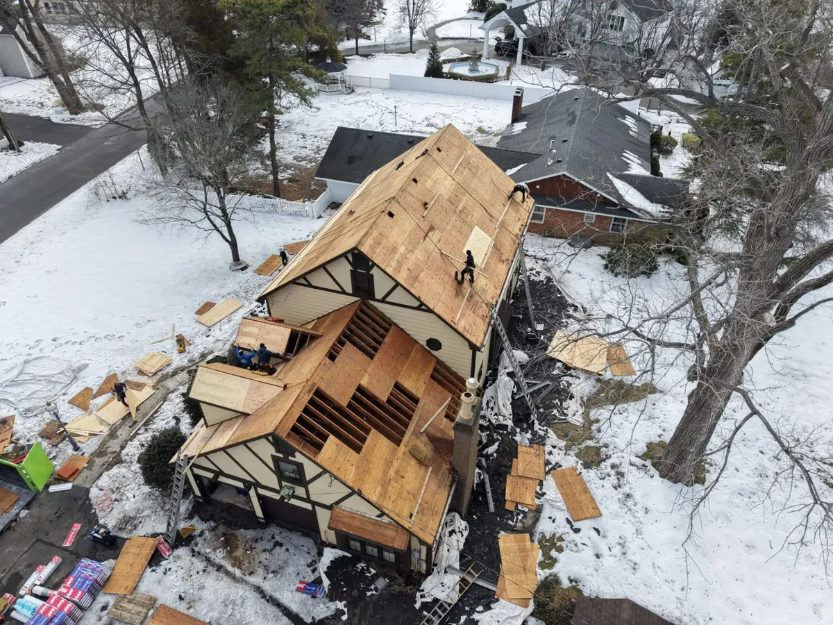 Pujols crew sheathing the stripped roof of an 85-year-old Tudor home with new plywood in winter, Toms River, NJ.