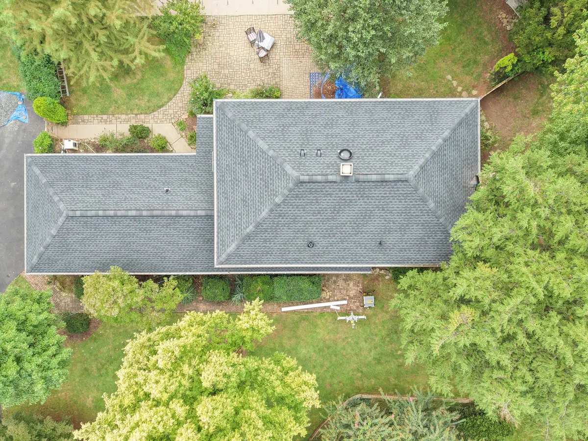 Drone view straight down on the new gray roof of a large white colonial on Montgomery Avenue in Rocky Hill, NJ, by Pujols Roofing.