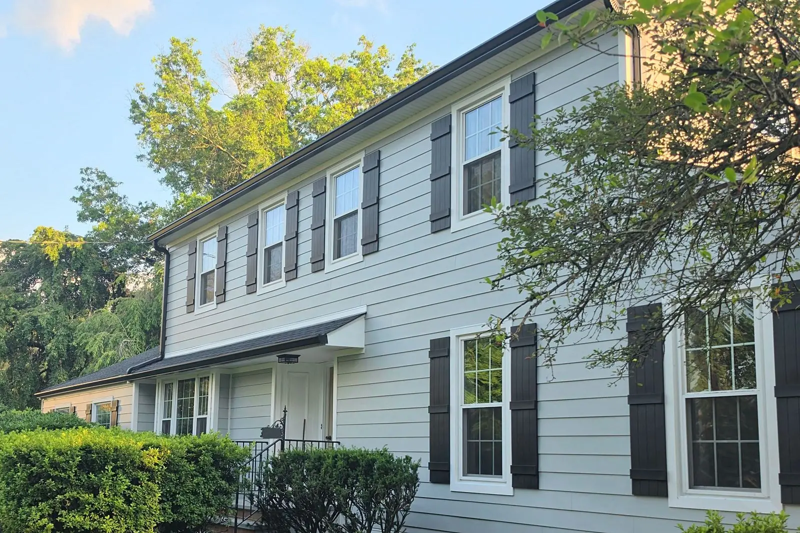 James Hardie smooth lap siding in Light Mist with black shutters on a colonial in Princeton, NJ by Pujols Roofing & Siding LLC.