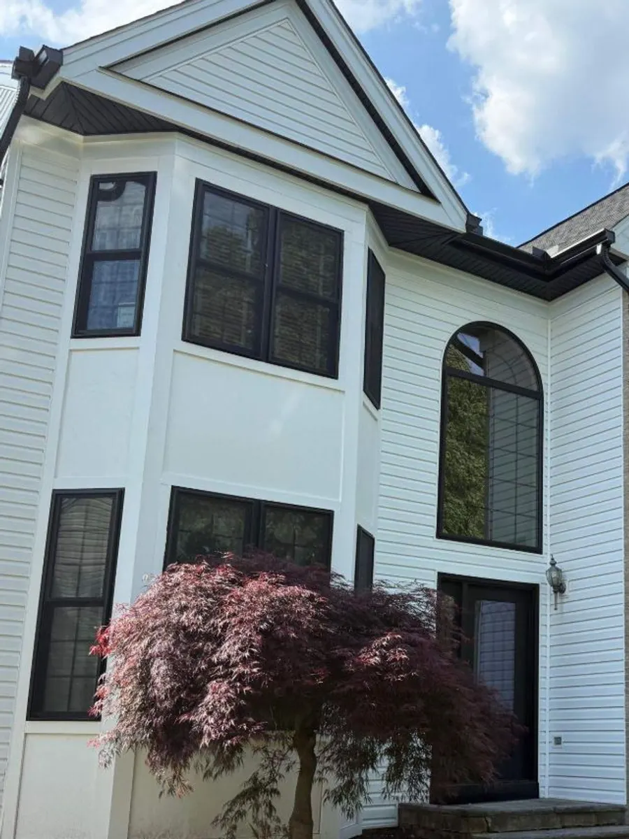 Black ProVia Endure replacement windows, including a bay and an arched window, with bug screens on a white home in South Plainfield, NJ.